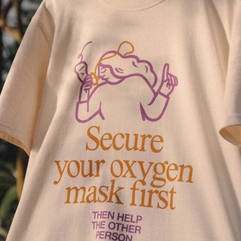 T-Shirt Calma: Secure your mask first, then help the other person
